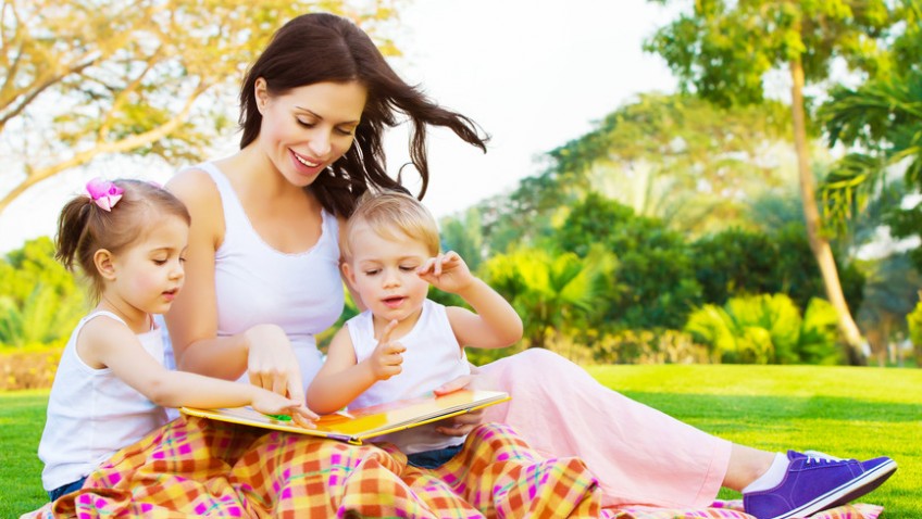 Woman with daughter and son read fairytale